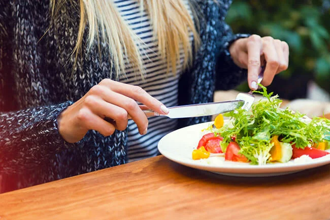Restaurant customer eating vegetable salad at table