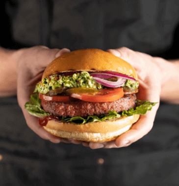 Grilled plant-based meat patties on plate with vegetables