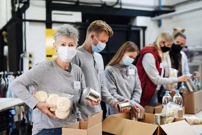 Masked volunteers working at local food donation charity