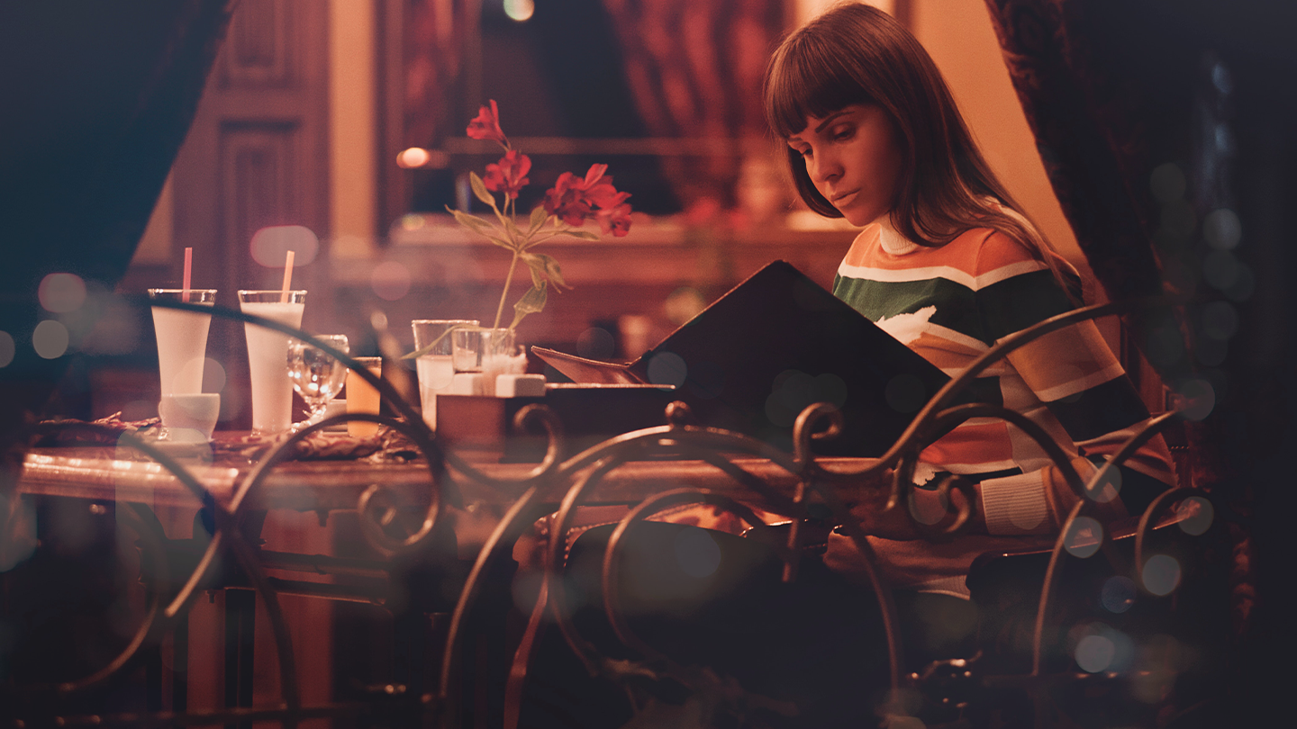 Woman Reading Menu in Restaurant