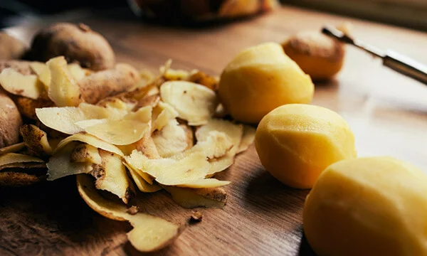 Peeled potatoes with potato skins