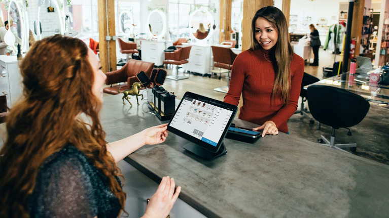 Smiling restaurant worker using POS system