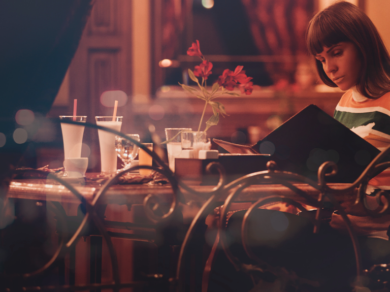 Woman Reading Menu in Restaurant
