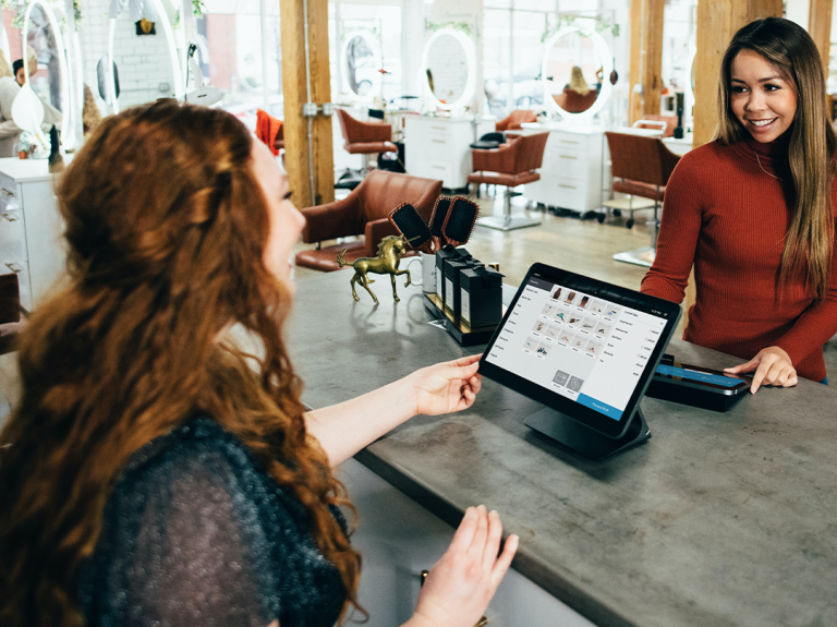 Smiling restaurant worker using POS system