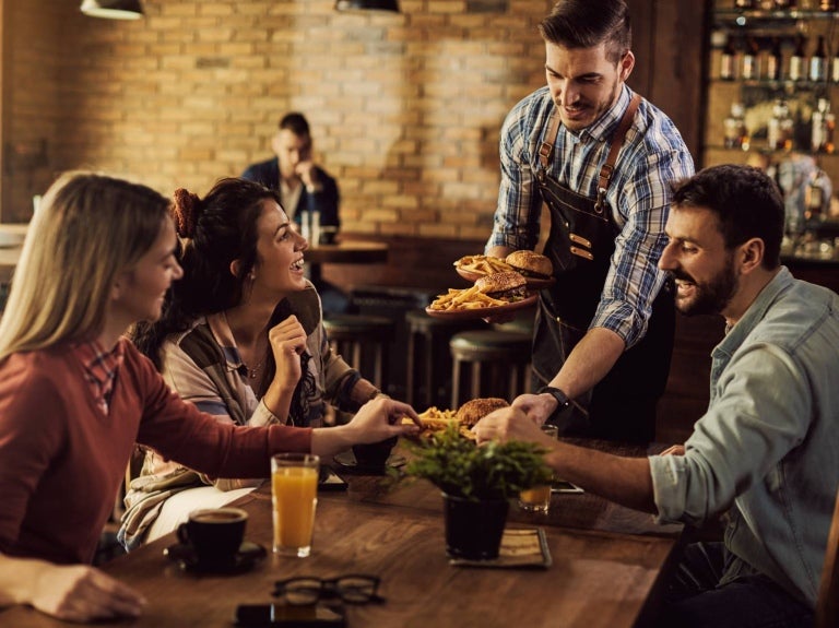 Food runner serves a group of customers in a restaurant