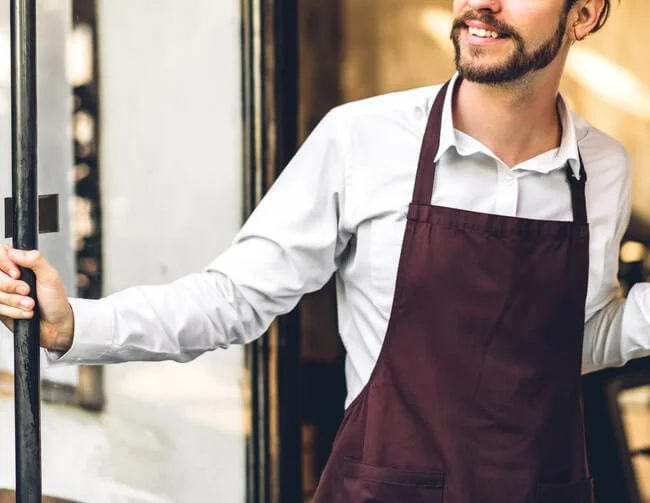 Smiling barista outside coffee shop